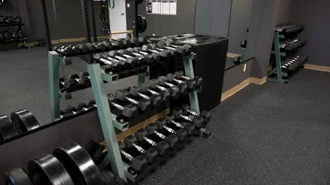 Hex dumbbell rack with mirror reflection in modern studio strength gym Stock Footage 330620664