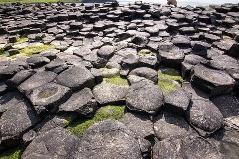 Hexagonal basalt columns at Giants Causeway Northern Ireland with sunburst .. Фото