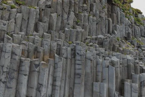 Hexagonal Basalt Columns with Greenery in Iceland's Rugged Landscape Stock-Fotos