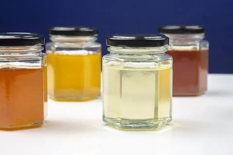 Hexagonal jars with different types and colors of fresh flower honey. vitamin Stock Photos