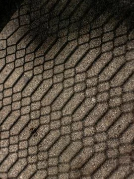 Hexagonal Net Shadow Pattern Cast on Sand Textured Ground Surface Stock Photos