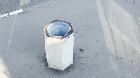 Hexagonal public trash bin stands on a sunny city pavement Stock Footage 336937159
