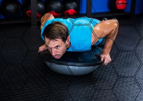 Hexagonal shapes pattern against caucasian fit man working out at the gym Stock Photos