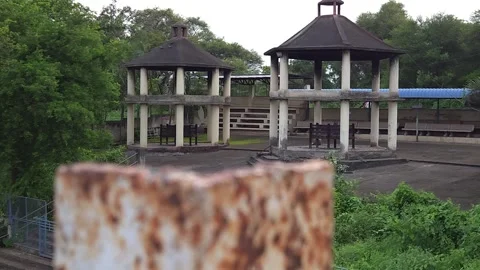 Hexagonal stone pavilions inside an empty cremation courtyard framed behind a we Video stock 342477424