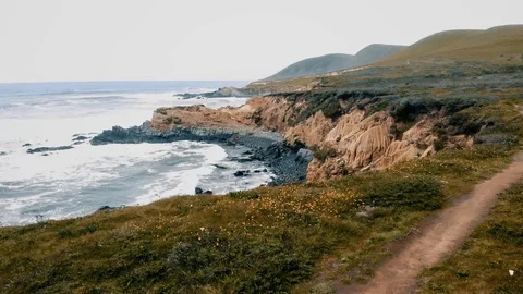 HHC187_Flying level with mini cliffside moving forward as waves crash underneath Stock Footage 116857120