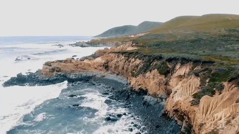 HHC188_Flying level with mini cliffside moving backward as waves crashing Stock Footage 116857181