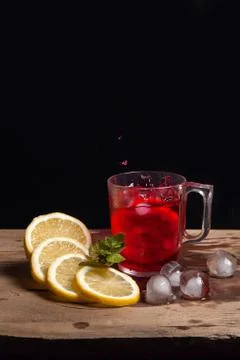 Hibiscus cold tea splash from the fallen slice of lemon into glass with bever Stock Photos