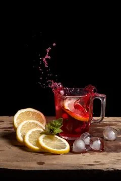 Hibiscus cold tea splash from the fallen slice of lemon into glass with bever Stock Photos