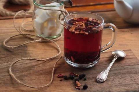 Hibiscus tea with fruit pieces and sugar in glass Stock Photos
