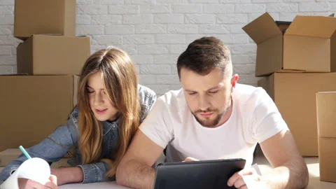 Hidden camera idea. Couple lies on the floor. Man discover hiden camera. Video stock 88099520