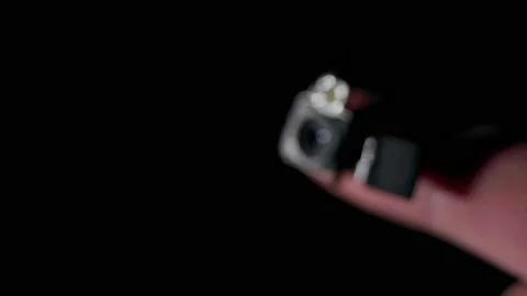 A hidden camera module that fits on a finger on a black background disappears Stock Footage 172005213