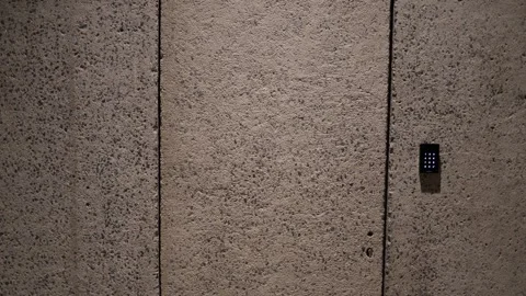 A hidden door seamlessly blends into the concrete wall, its presence betrayed on Stock Footage 304287667