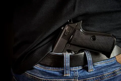 Hidden gun back side to man in blue jeans Stock Photos