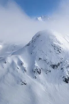 Hidden mountain peak in pristine alpine landscape. Calm and tranquil winter s Stock Photos