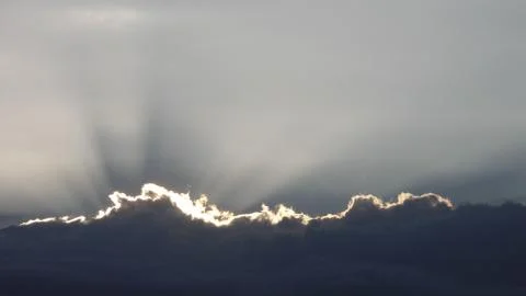 Hidden Sun Sunset behind the clouds Stock Photos