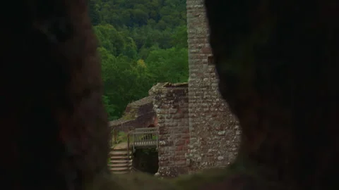 A hidden view through stone reveals part of an old castle Stock Footage 309357929