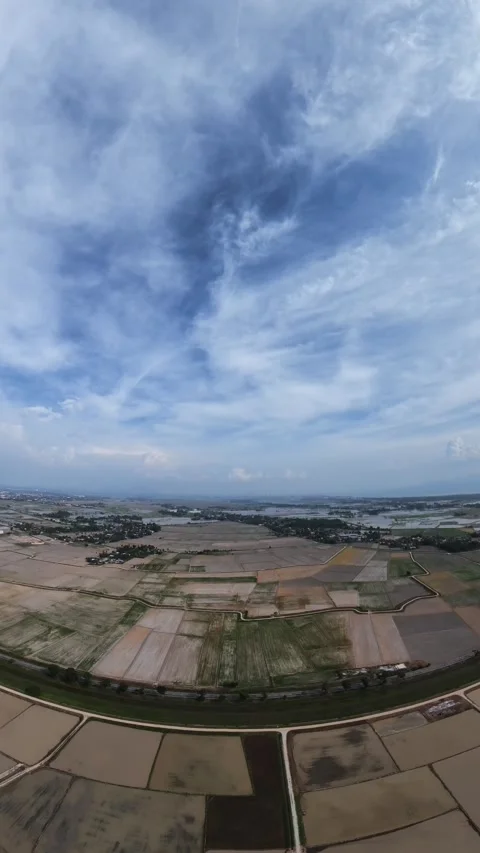 High above, clouds drift over patchwork fields Stock Footage 345409046