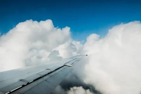 High above the clouds, the sky viewed from inside the airplane - wing view pe Stock Photos