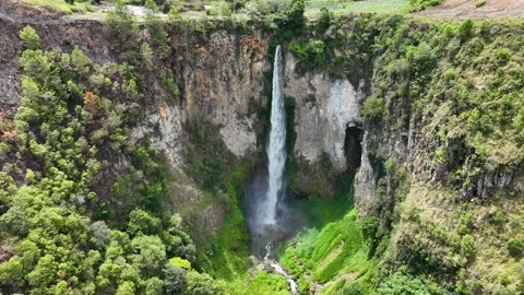 From high above, Sipisopiso slices down the rock face into a vivid green gorge Stock Footage 328220957