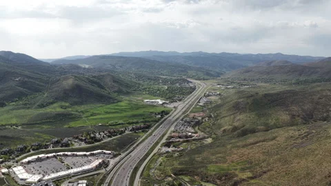 High aerial above Interstate 80 through Park City Utah in spring cloudy sky Stock Footage 335798402