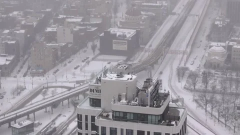 High aerial across Williamsburg rooftops and streets during heavy snowfall Stock Footage 342118128
