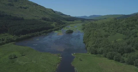 High aerial approaching Loch Dochart in lush green glens, classic Highland Stock Footage 115500518