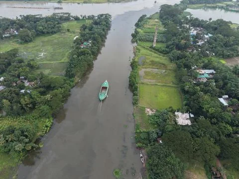 High aerial drone view of a cargo vessel sailing through a rural river stream Stock Photos