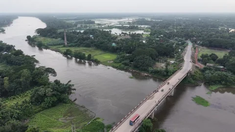 High aerial drone view of a long road bridge over a wide river in a village Stock Footage 341520579