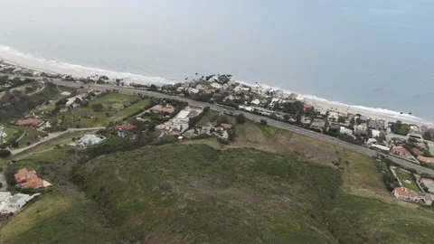 High aerial looking down from green rolling hills to Malibu coastline Stock Footage 208808683