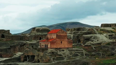 High aerial perspective of Uplistsikhe ancient rock city surrounded by valleys Stock Footage 335476586