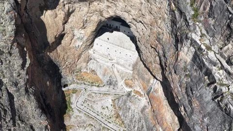 High Aerial Pullback Revealing Ancient White Rock-Carved Cliffside Structure Stock Footage 339469010