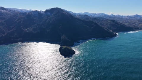 High Aerial Pullback Revealing Island Coastline and Snowy Forest Mountains Stock Footage 343155518