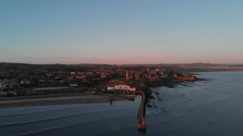 High aerial pullback from St Andrews East Sands at sunrise Stock Footage 147598830