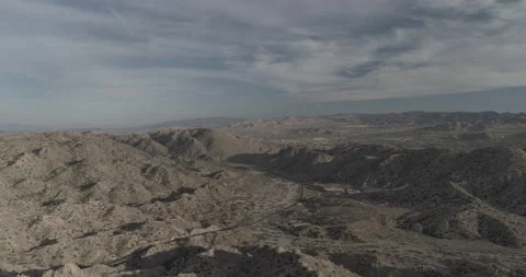 High aerial pushes down into a valley outside of Yucca, California on sunny day Stock-Footage 150773123