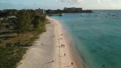 High Aerial shot moving along beach watching people walk and waves crash Stock Footage 112720586