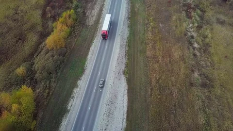 High Aerial view of alone red truck driving an interstate highway with trailer Stock Footage 176405800