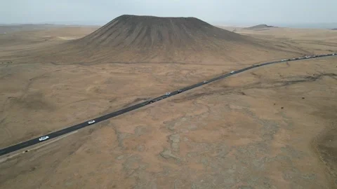 High aerial view of desert volcanic cone and straight road in Xinjiang China Stock Footage 337765438
