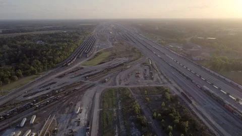 High Aerial view of a freight train yard and moving train at sunset Stock Footage 127726358