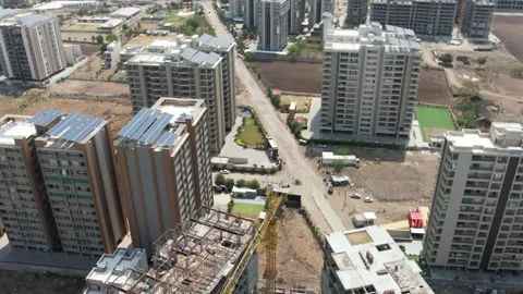 High aerial view of open plot land along city street near apartments. Stock Footage 347705945