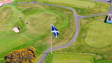 High aerial view of the Scottish flag waving over a green golf course Video stock 334633726