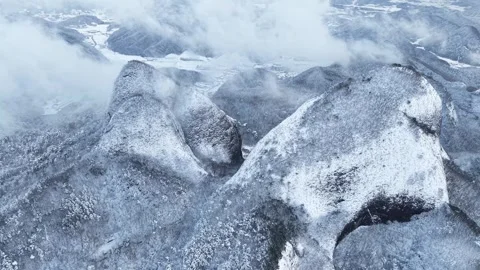 High Aerial View of Snowy Mountain Peaks with Fast-Moving Clouds Stock Footage 344248162