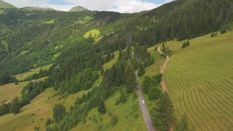 High aerial view of a white camper van driving along a narrow mountain road Stock Footage 342324355