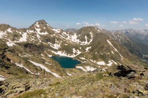 High alpine landscape with snow fields and lakes in the region Ordino Arcalis Foto stock