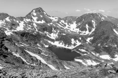 High alpine landscape with snow fields and lakes in the region Ordino Arcalis Stock Photos