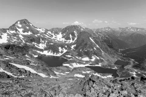 High alpine landscape with snow fields and lakes in the region Ordino Arcalis Stock Photos