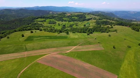 High altitude aerial pull back shot flying backward over green plateau Serbia Stock Footage 342241478