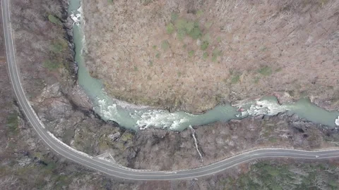 High altitude aerial slow motion view of a mountain river and scenic road Stock Footage 337542563