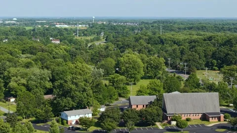 High Altitude Aerial Toward Maple Lawn Over Trees and Suburban Landmarks Stock Footage 336699157