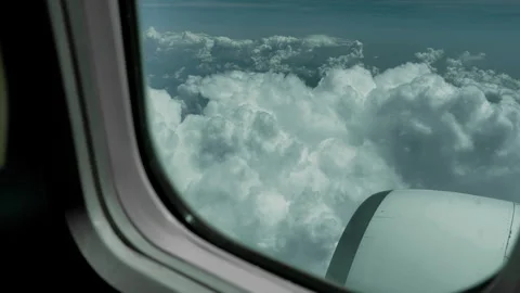 High Altitude Aerial View of Fluffy White Clouds Framed by Airplane Window Stock Footage 337948939