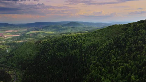 High-altitude aerial view from a forested edge over a lowland valley with Vídeos de archivo 336316109